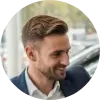 A circular profile picture of Michael Shaw, a car dealership owner, smiling.