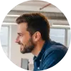 A circular profile picture of Tom B., a software development lead, smiling.